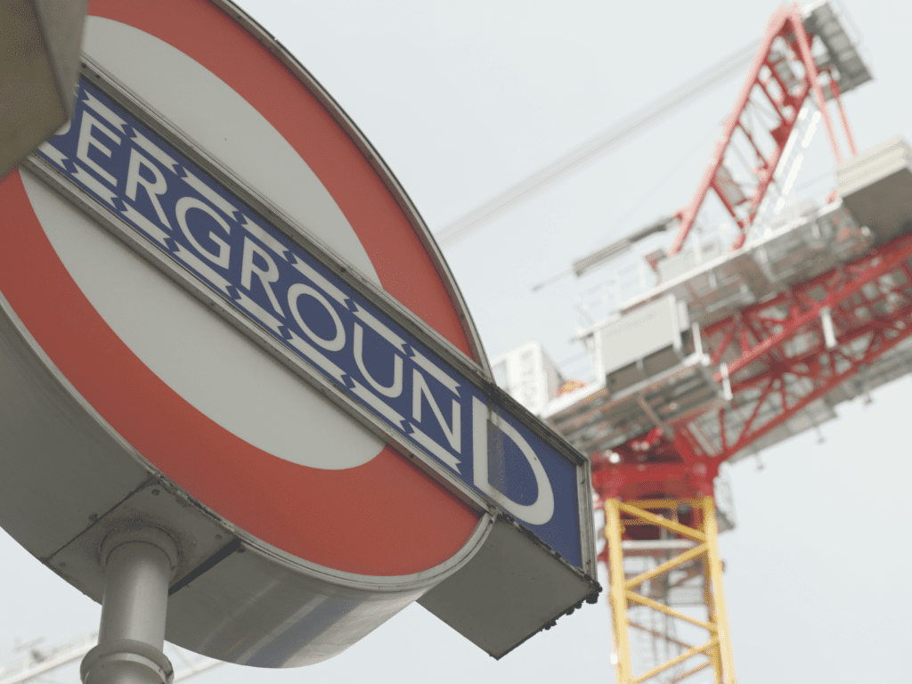 Tower crane behind an underground sign in London